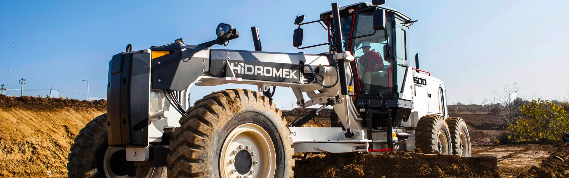 Homme conduisant une chargeuse pelleteuse de la marque Hidromek