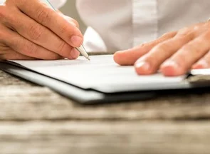 Une main tenant un stylo et signant un document
