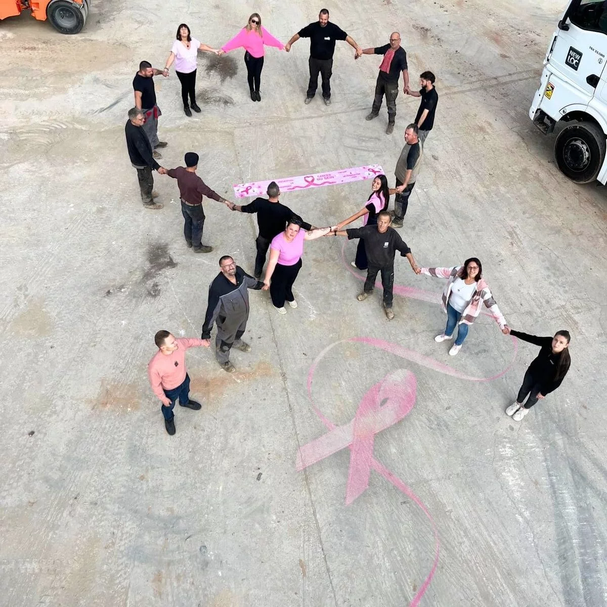 Nos équipes réunies pour Octobre Rose en formant le ruban, symbole de soutient et de solidarité.